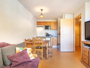 ein Wohnzimmer mit einem Sofa und einem Tisch sowie eine Küche in der Unterkunft Les Marmottes- 35 Appart Lumineux- 5 pers in Saint-Sorlin-dʼArves