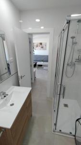 baño blanco con ducha y lavamanos en vivienda fines turisticos, en Málaga