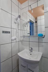 a white bathroom with a sink and a mirror at Janosik in Kluszkowce