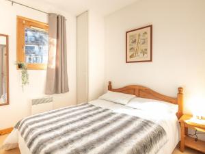 um quarto com uma cama com um cobertor listrado em Les Bouquetins - 5 - Appart Chaleureux 6 pers em Saint-Sorlin-dʼArves