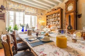 a dining room with a long table with orange juice on it at La maison bleue in Arquian