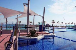 a swimming pool with umbrellas next to a swimming pool at Sea Senses Blue Ocean in Torrevieja