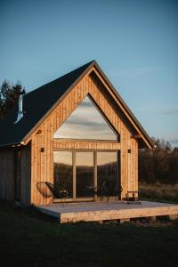 a barn with a large window and two chairs on a deck at Osada Augustów in Mirsk