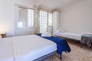 a bedroom with two beds and two windows at Town center Apartment El Perello Valencia in Valencia