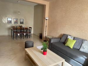 uma sala de estar com um sofá e uma mesa em Comme à la maison 1 em Nouaseur