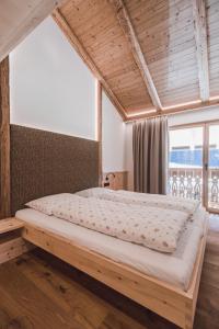 a large bed in a room with a large window at Mudlerhof in Prateria