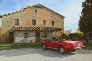 a red car parked in front of a brick house at Molenda B&B in Città di Castello
