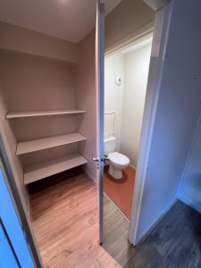 - une petite salle de bains avec des toilettes et une porte dans l'établissement Studio La Marmotte Appart 327, à La Féclaz