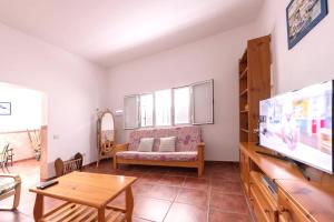 Las Marciegasにある3 bedrooms house at Los Caserones 50 m away from the beach with enclosed garden and wifiのリビングルーム(ソファ、テレビ付)