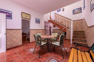 uma sala de jantar com uma mesa e cadeiras e uma escadaria em 3 bedrooms house at Los Caserones 50 m away from the beach with enclosed garden and wifi em Las Marciegas