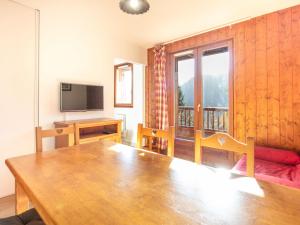 a living room with a wooden table and a television at Les Ecureuils - A09 - Appart Chaleureux - 6 pers in Saint-Sorlin-dʼArves