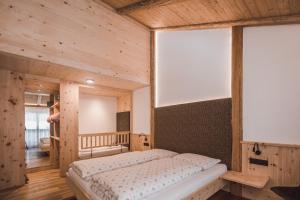 1 dormitorio con 1 cama en una habitación de madera en Mudlerhof, en Prateria