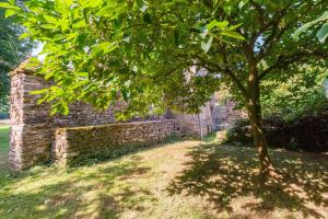 ein Baum vor einer Ziegelmauer in der Unterkunft Gîte de l'Abbaye in Brandivy