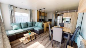a living room and kitchen with a couch and a table at jpp marie ange proprietaire in Saint-Julien-en-Born