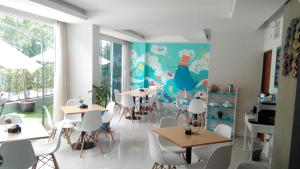 a dining room with tables and chairs and a mural at By Dee at Jomtien in Jomtien Beach