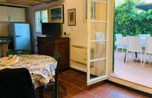 a room with a table and a television and a patio at Dante Appartamento con giardino in Levanto