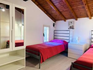 a bedroom with two beds and a mirror at Dante Appartamento con giardino in Levanto