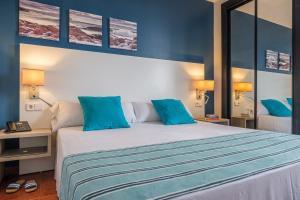a bedroom with a large bed with blue walls at Estival Islantilla in Islantilla