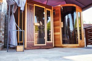 une maison en bois avec des portes en verre sur une terrasse dans l'établissement Casa Chilia Resort&Spa, à Chilia Veche