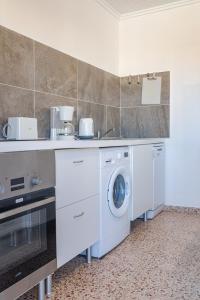 a kitchen with a washing machine and a sink at Town center Apartment El Perello Valencia in Valencia