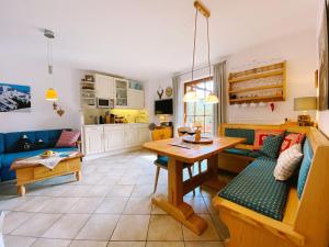 een keuken en een woonkamer met een tafel en een bank bij Ferienwohnung Schober in Reit im Winkl