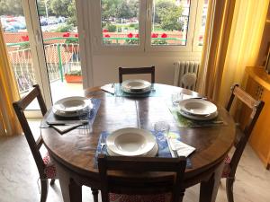 a dining room table with chairs and a wooden table with plates at Questa casa non è un albergo CIU-ATR 9390-9 in Rome