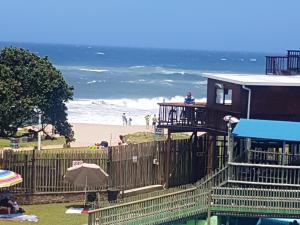 a house on the beach with the ocean in the background at Barefoot Bungalo in Amanzimtoti