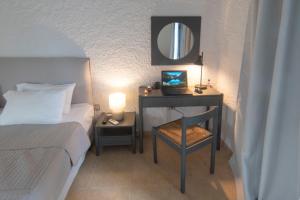 a bedroom with a bed and a desk with a mirror at Apollo Resort in Agia Marina Aegina