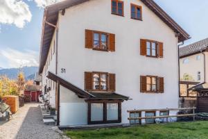a large white house with wooden windows at Höllental 51 in Garmisch-Partenkirchen