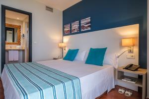 a bedroom with a large white bed with blue walls at Estival Islantilla in Islantilla