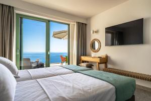 a hotel room with a bed and a large window at Joy Aqua in Skala