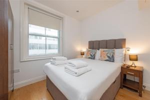 a bedroom with a large bed with towels on it at Stayo Oxford Street in London