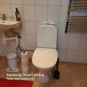 La salle de bains est pourvue de toilettes blanches et d'un lavabo. dans l'établissement Naturnära dubbelrum B&B i Uppsala Ramstalund, à Uppsala