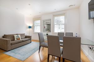 ein Wohnzimmer mit einem Tisch, Stühlen und einem Sofa in der Unterkunft Stayo Oxford Street in London