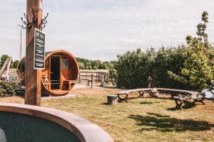 een park met een speeltuin met een tent en banken bij CRASH'NSTAY - N° 9 in Sprang-Capelle