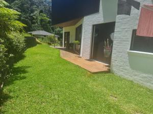 a yard with a wooden deck next to a house at RESIDENTIAL 4 BEDROOM House in Coffs Harbour
