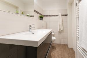 a white bathroom with a sink and a toilet at Blankwasserweg 131 Lensterstrand Oase Bungalow 7 in Lenste