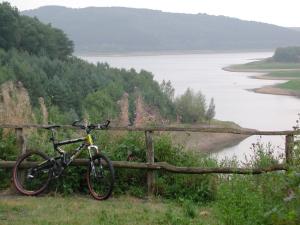 a bike parked on a fence next to a lake at Hotel Meyer in Kürten