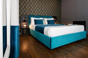 um quarto com uma cama azul com almofadas azuis e brancas em Hotel 87 eighty-seven - Maison d'Art Collection em Roma