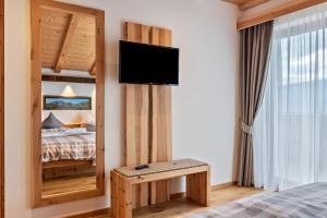 a bedroom with a bed and a tv on a wall at Hatzes App Panorama in Laion