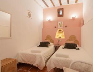 two beds in a room with pink walls at Casa rural con jacuzzi y chimenea en paraje único - La Casa del Pino in Blanca