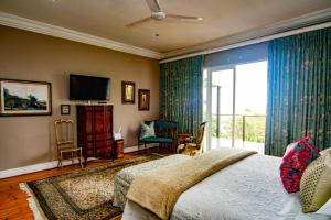 a bedroom with a bed and a tv and a balcony at Pete's Place in Durban