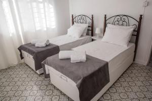 two beds in a hotel room with towels on them at Templar Guesthouse in Famagusta