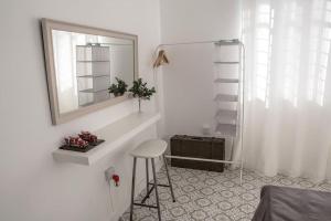 a white room with a stool and a mirror at Templar Guesthouse in Famagusta