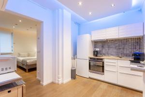 eine Küche mit weißen Schränken und ein Bett in einem Zimmer in der Unterkunft Victor Hugo Flat in Paris