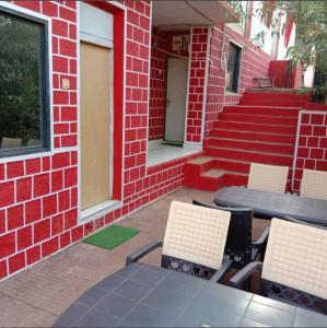 un patio con sillas y mesas y un edificio de ladrillo en altafs motel, en Matheran