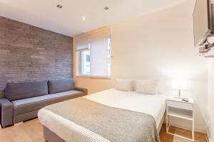 ein Schlafzimmer mit einem Bett und einem Sofa in der Unterkunft Victor Hugo Flat in Paris