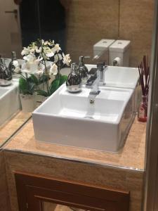 La salle de bains est pourvue d'un lavabo blanc et d'un miroir. dans l'établissement Acogedor apartamento en Edif. Slalom II, à Monachil