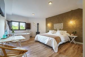 1 dormitorio con 1 cama grande y bañera en DUO SOMNIA, suites con jacuzzi y chimenea, only adults, 