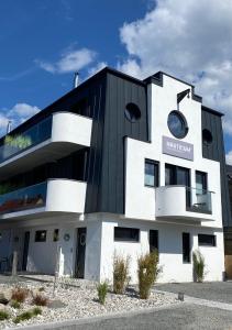 ein schwarzweißes Gebäude mit einem Schild darauf in der Unterkunft Lubminer Meerblick Apartments in Lubmin